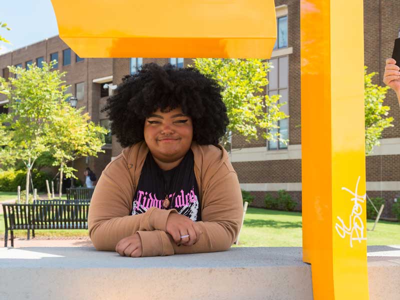 a smiling v.c.u. student sitting outside on a sunny day